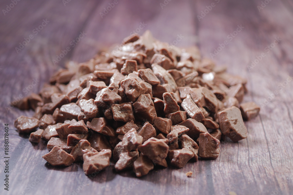 Obraz premium Chocolate pieces arranged on a wooden table surface
