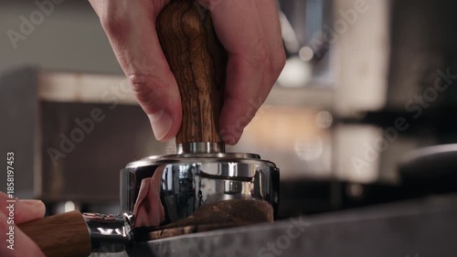 Slow motion spreading fresh ground coffee in basket of bottomless portafilter