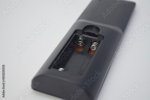 Close-up of an open battery compartment in a black plastic device showing metallic spring contacts