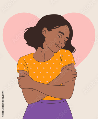 A beautiful young woman with curly hair wears a bright yellow polka dot top, gently embracing herself against a soft pink heart background, showcasing self-love and confidence.