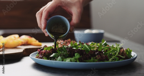 Wallpaper Mural man making salad with nectarines and mozzarella on a blue plate on concrete countertop on kitchen, add dressing Torontodigital.ca