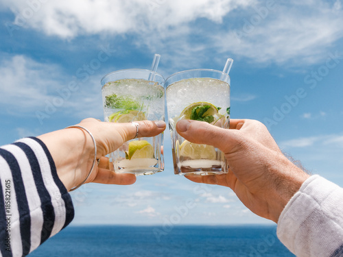 Men's and women's hands and glasses with drinks. Cruise ship deck. Against the backdrop of sea waves. Vacation and travel concept. Chill lifestyle, luxury travel. Perfect for holiday and travel themes