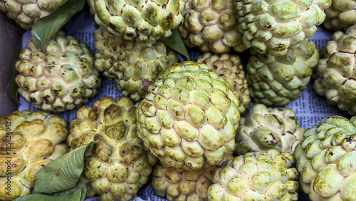 fresh custard apples stacked together in cardboard box for retail sale