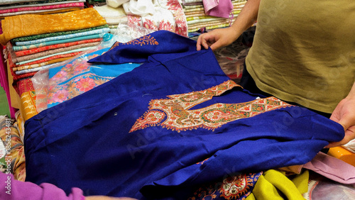 embroidered kurti textile with traditional floral patterns showing to customer