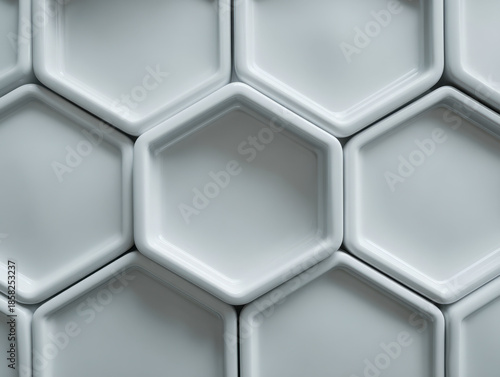 Pattern of interconnected smooth hexagonal ceramic tiles creating a modern geometric 3d wall texture in soft gray tones for design background