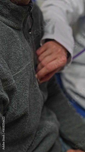 Close-up view of a physician's hand holding a stethoscope on an elderly male patient's chest during a medical examination in a clinic