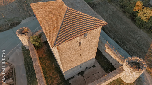 Elevated view of historic stone tower and fortified walls in rural Spain