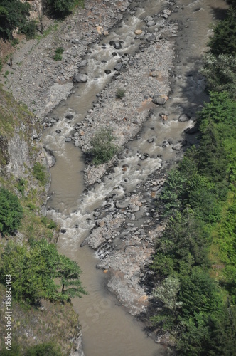 River flowing through rocky terrain with trees along the banks in a natural landscape