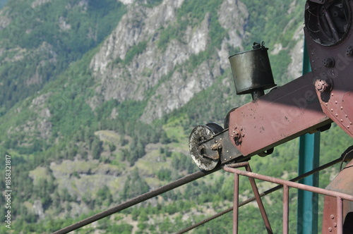 Cable pulley system overlooking a green mountain valley on a sunny day with clear skies in late spring