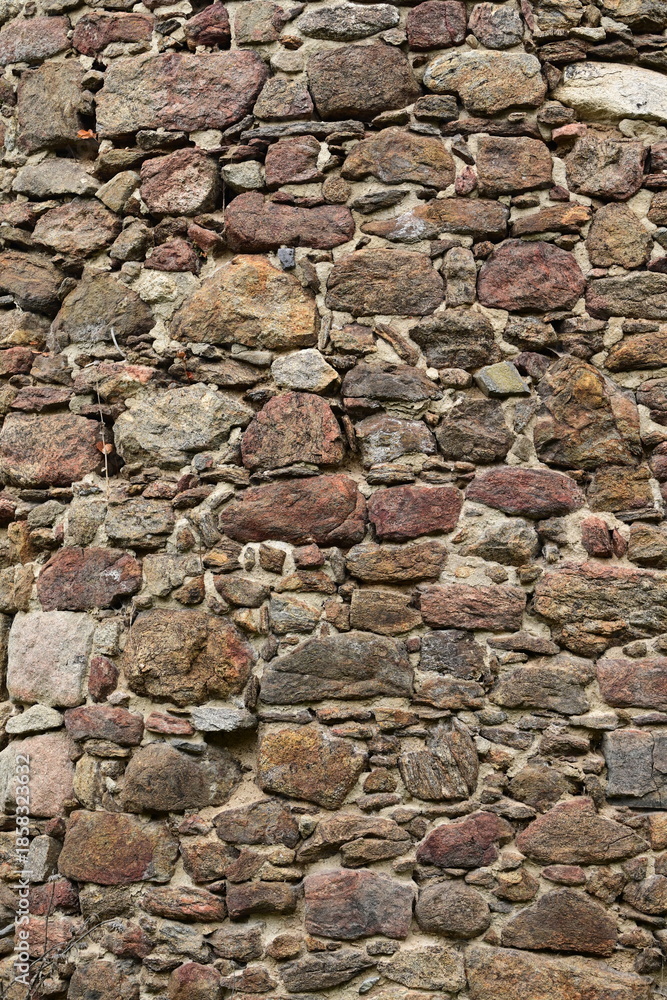 Fototapeta premium Bruchsteinmauer, rötlicher alte Mauer aus Granitsteinen