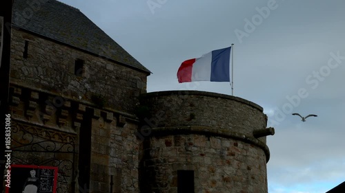 Mont-Saint-Michel, Normandy, 08-24-2024. French flag waving inside the walls of Mont Saint Michel. Super slow motion 4K