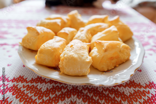 Freshly baked homemade cheese puff pastry buns on a rustic wooden board