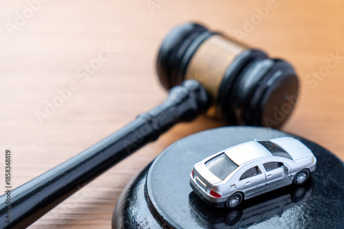 фотографія A judge gavel and a miniature car on a wooden table