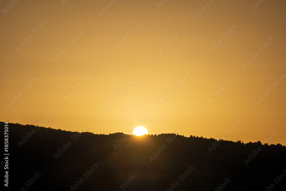 custom made wallpaper toronto digitalA golden sunset over calm lake waters with a reflective trail of light leading to the silhouettes of hills. Warm orange tones fill the sky, creating a serene twilight landscape ideal for sunset themes