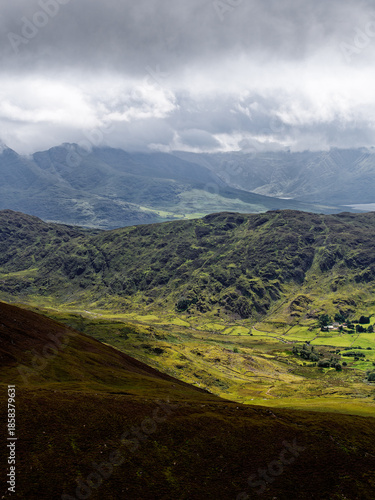 Dramatic interplay of light and shadow across mountain ridges. The varied textures and cool tones enhance the mood, creating a captivating vista.