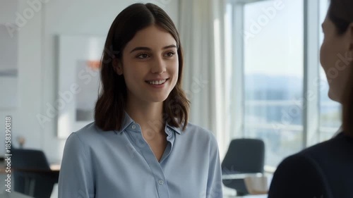 Young business woman smiling gently during a conversation in an office