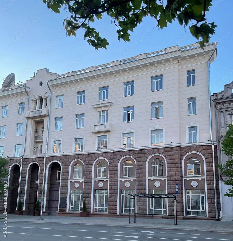 Naklejka premium Brightly lit historic building showcases architectural features on a calm morning