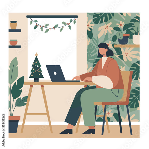 Woman working remotely on a laptop in a modern home office decorated for the Christmas holidays