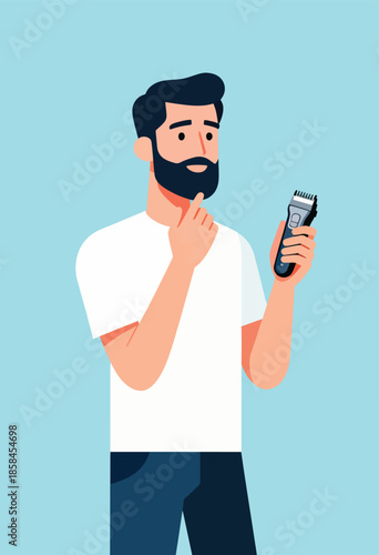 Thoughtful bearded man in white shirt holds electric trimmer, considering grooming