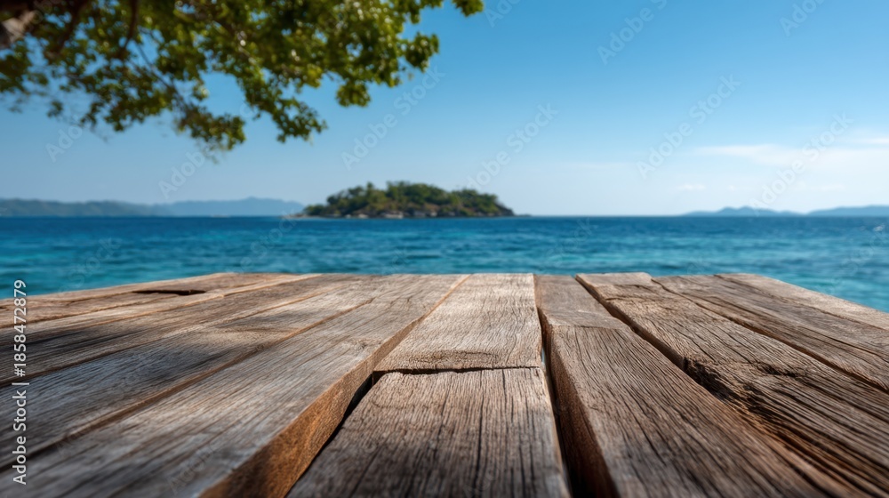 Fototapeta premium A serene view from a rustic wooden deck looking out to a tropical island in the azure sea. The gentle waves and clear blue sky create a tranquil atmosphere perfect for relaxation.