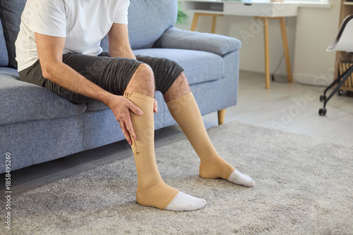 Quadro su tela Man using compression stockings for varicose veins therapy at home