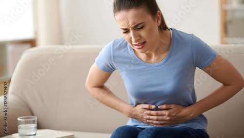 Woman Suffering from Stomach Pain on Sofa at Home