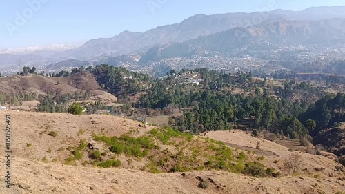 Rolling hills with sparse vegetation overlooking a small town