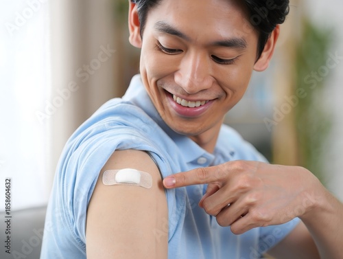 Smiling Man Shows Bandage on Arm After Vaccination
