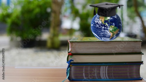 Three books and a round earth wearing a toga on a wooden table with a garden background. International Education Day.