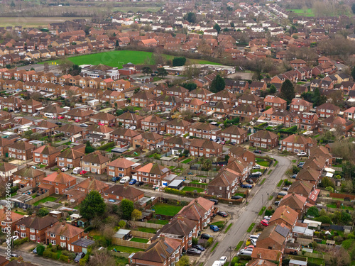 Aerial drone photo of the village of Huntington in the City of York in North Yorkshire England showing rows of typical British houses and housing estates with roads, streets and gardens from above