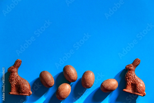 Wallpaper Mural Easter chocolate bunnies and chocolate eggs on blue background. Top view Torontodigital.ca
