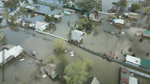 Aerial drone footage of a massive city flood with houses and streets submerged under water. Urban flooding caused by extreme weather and heavy rainfall, showing natural disaster impact on residential 