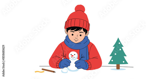 Creative young boy wearing a warm red hat and blue scarf carefully builds a small snowman on a tabletop beside a tiny pine tree.