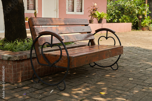 A unique wooden bench with backrest in the front yard of the house                      
