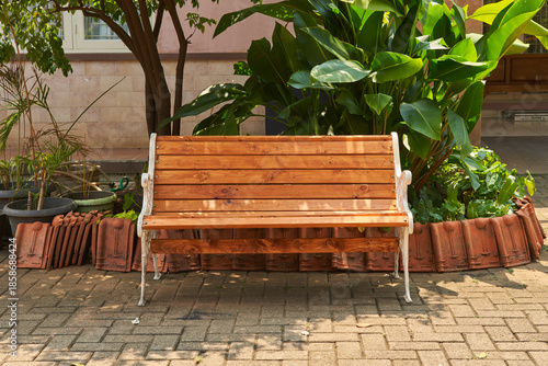 A classic wooden backrest bench in the outdoor garden area                       