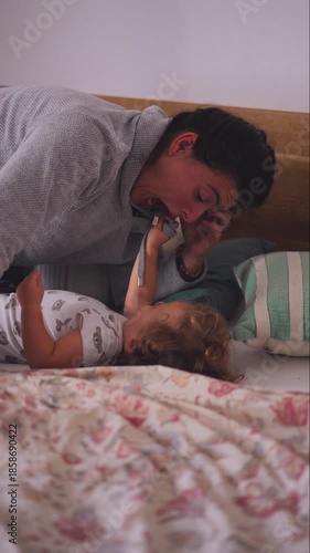Mother lying beside toddler on bed making playful faces expressing affection emotional bonding and quiet shared presence during intimate family time