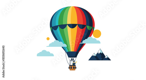 Vibrant rainbow colored hot air balloon flying in a blue sky among fluffy clouds above snow-capped mountain peaks.