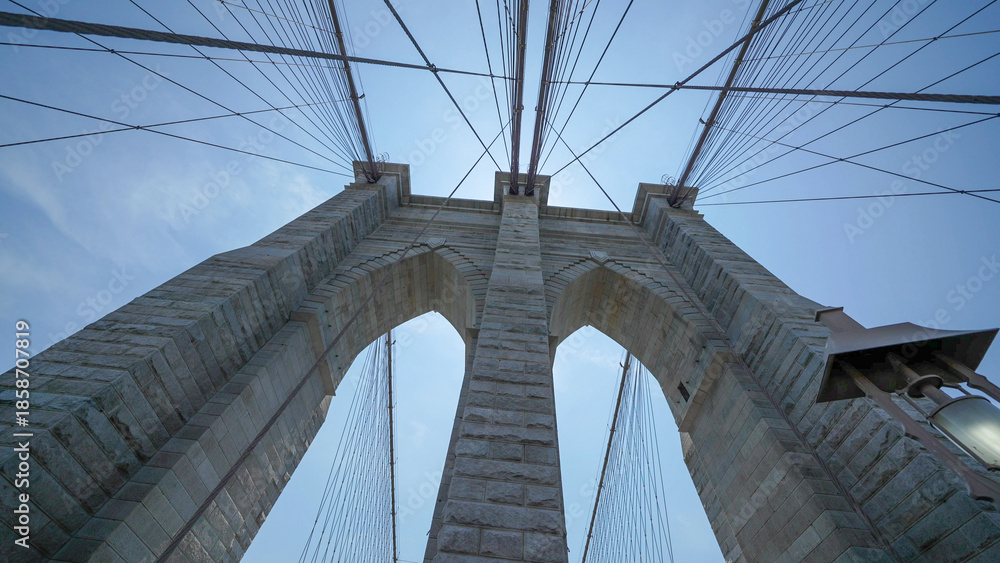 Fototapeta premium Brooklyn Bridge stone pillars captured from below highlighting structural details and grandeur