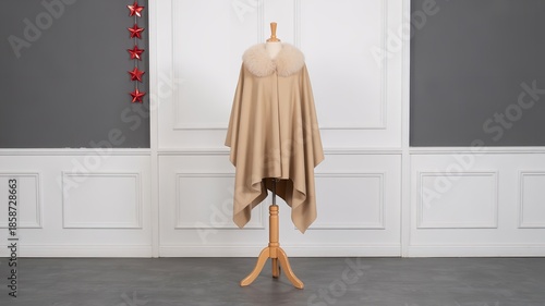 Elegant Beige Oversized Cape with Faux Fur Collar Displayed on Mannequin Against White and Grey Paneled Wall