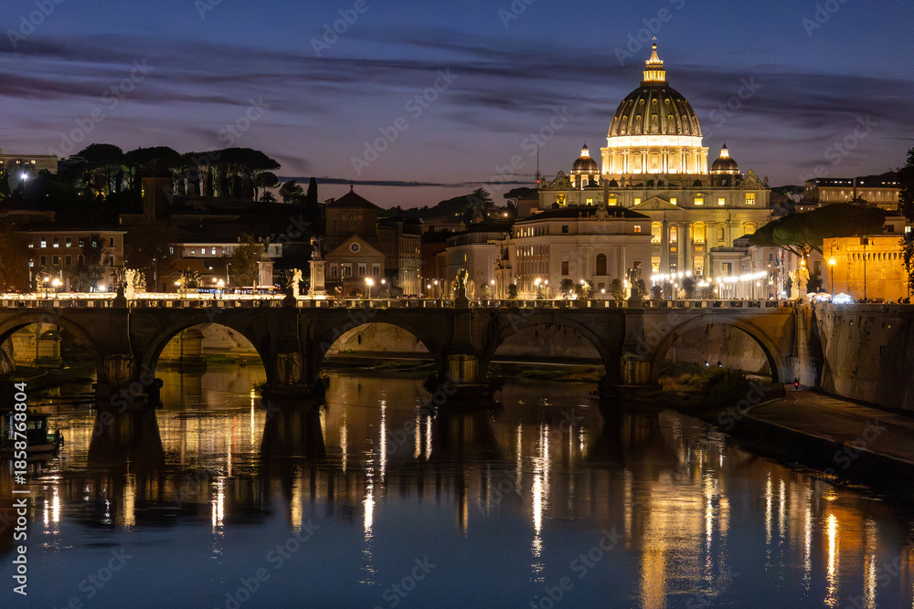 Fototapeta premium View of St. Peter's Basilica in Vatican City and the Sant'Angelo Bridge and the Tiber River, from the Umberto I Bridge, at dusk in Rome, Italy.