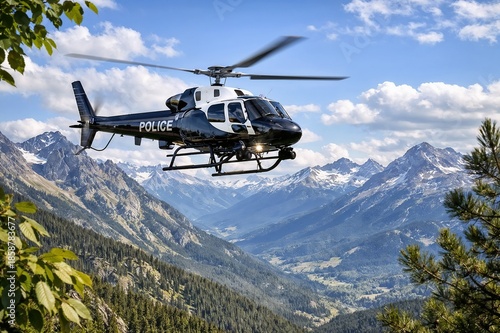 Police helicopter in flight over mountainous landscape with snow-capped peaks and lush green forests