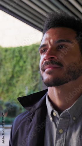 Vertical HD video of young businessman walking with confidence near a modern office building, representing success, ambition and positive professional attitude. Corporate and business concept