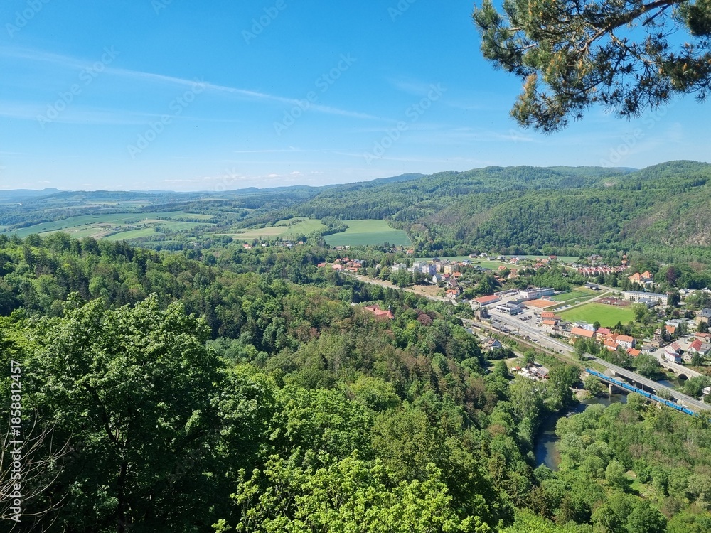 Obraz premium Panoramic viewpoint over Bardo Śląskie and the Kłodzko Valley. Green hills, the Nysa Kłodzka River and a small town create a peaceful landscape of southern Poland.