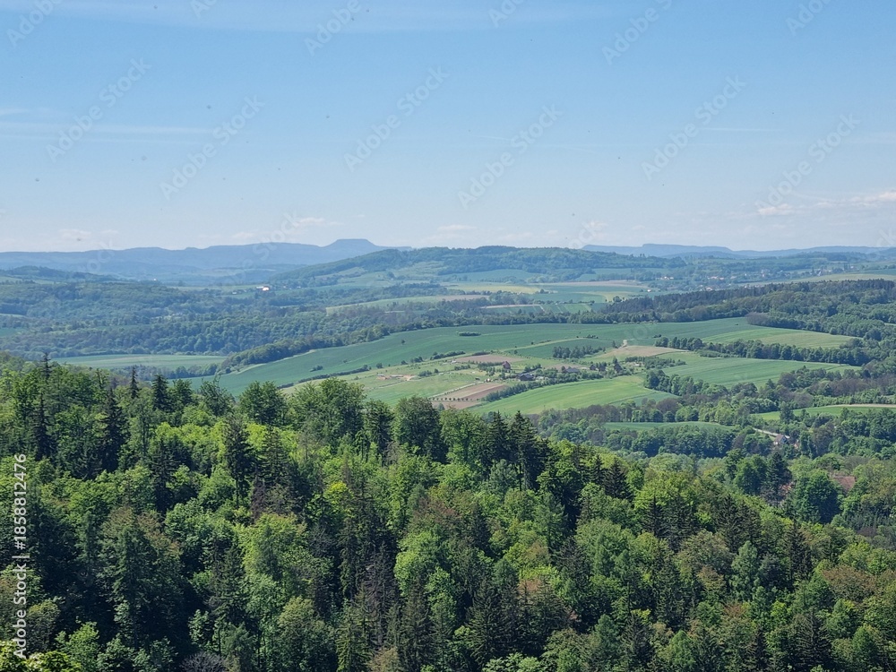 Fototapeta premium Panoramic viewpoint over Bardo Śląskie and the Kłodzko Valley. Green hills, the Nysa Kłodzka River and a small town create a peaceful landscape of southern Poland.