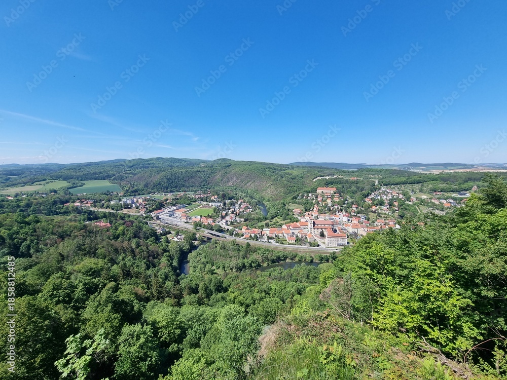 Obraz premium Panoramic viewpoint over Bardo Śląskie and the Kłodzko Valley. Green hills, the Nysa Kłodzka River and a small town create a peaceful landscape of southern Poland.