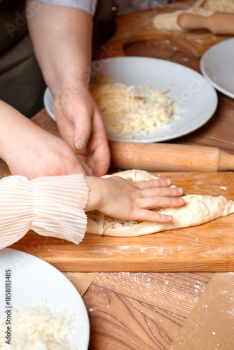 The chef's hands and the child's hands work together at a children's baking master class.