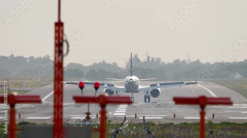 Footage of jet passenger plane landing, touching the runway. Airliner slowing down, rear view. Flight arriving