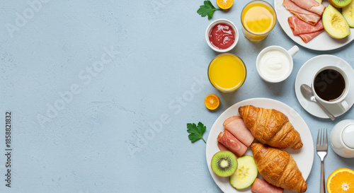 Delicious breakfast spread with croissants, fruits, and coffee on light blue background
