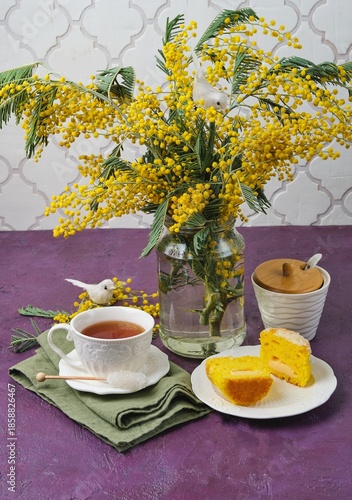 Mimosa cupcakes on a white cake stand against a purple concrete background.