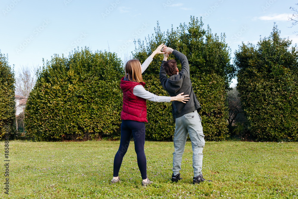 Fototapeta premium rear view of two persons exercising in the park